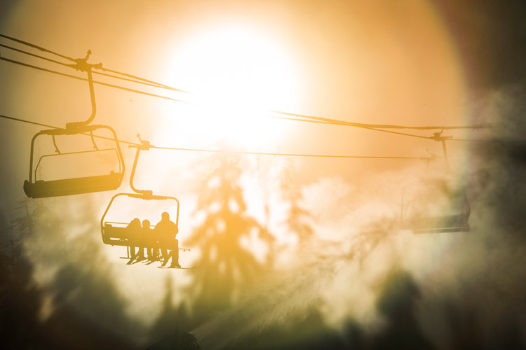 Silhouetted skiers on Whistler mountain
